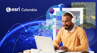 Hombre sonriendo frente al computador con audífonos en su cabeza