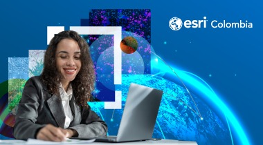 Mujer joven sonriendo frente al computador mientras toma nota en un cuaderno
