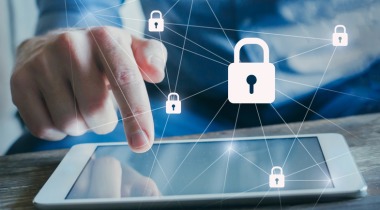 Manos interactuando con una tableta digital, con iconos de seguridad digital.